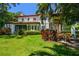 Expansive backyard with lush lawn, mature trees, and a covered patio, perfect for outdoor entertaining at 808 Idlewood Ave, Tampa, FL 33609