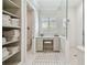 Bright bathroom featuring vanity, storage, shower with glass door, and patterned tile floor at 808 Idlewood Ave, Tampa, FL 33609