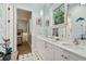 Bathroom featuring double sinks, white vanity, and view to bedroom with a glimpse of the outside at 808 Idlewood Ave, Tampa, FL 33609