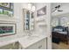 Bathroom vanity featuring marble countertop, decorative mirror, art, and view into bedroom at 808 Idlewood Ave, Tampa, FL 33609