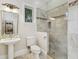 Bright bathroom featuring pedestal sink, decorative tile accents, and glass-enclosed shower with stone tile at 808 Idlewood Ave, Tampa, FL 33609