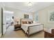 Bedroom with shuttered windows, carpet, and view into an adjacent room with white sofa at 808 Idlewood Ave, Tampa, FL 33609