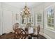 Bright dining room with decorative chandelier, round table and shuttered windows at 808 Idlewood Ave, Tampa, FL 33609
