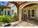 A covered patio area with stone flooring, and an outdoor grill cart near french doors at 808 Idlewood Ave, Tampa, FL 33609