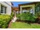 Exterior view of a home with a pergola-covered walkway and lush landscaping at 808 Idlewood Ave, Tampa, FL 33609