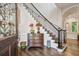 Grand foyer with dark wood flooring and a staircase with decorative iron railings and wood banister at 808 Idlewood Ave, Tampa, FL 33609