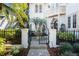 Gated entrance with stone fountain, lush landscaping, and a stone paver pathway leading to front door at 808 Idlewood Ave, Tampa, FL 33609