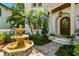 Front exterior of a home featuring a fountain, palm trees, and a charming entrance with a wooden door at 808 Idlewood Ave, Tampa, FL 33609
