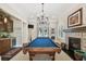 Bright game room features a fireplace, a bar, and a blue billiards table under a chandelier at 808 Idlewood Ave, Tampa, FL 33609