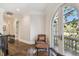 Upstairs hallway with dark wood floors, iron railing, and seating area with arched doors to a balcony at 808 Idlewood Ave, Tampa, FL 33609