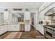 Modern kitchen featuring stainless steel appliances, granite countertops, white cabinets, and hardwood floors at 808 Idlewood Ave, Tampa, FL 33609