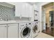 Laundry room with updated washer and dryer, mosaic tile and white cabinetry at 808 Idlewood Ave, Tampa, FL 33609