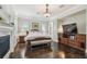 Bright bedroom with fireplace, wood floors, and a bench at the foot of the bed at 808 Idlewood Ave, Tampa, FL 33609