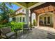 Covered outdoor patio with comfortable seating, a stone floor, and a view of the landscaped backyard at 808 Idlewood Ave, Tampa, FL 33609