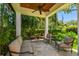 Covered patio with white pillars and ample seating overlooks lush, tropical landscaping at 808 Idlewood Ave, Tampa, FL 33609