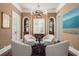 Inviting sitting room with custom shelving on either side of the window, with four chairs around a table at 808 Idlewood Ave, Tampa, FL 33609