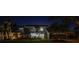 Night exterior of a well-lit two-story home with manicured landscaping and a two-car garage at 9011 Baywood Park Dr, Seminole, FL 33777