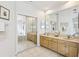 Bright bathroom featuring double vanity, large mirror, and closet with mirrored sliding doors at 10211 Quails Landing Ave, Tampa, FL 33647