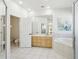 Bright bathroom with soaking tub, large mirror, double vanity and tiled floors and shower at 10211 Quails Landing Ave, Tampa, FL 33647