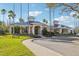 Community clubhouse featuring manicured landscaping, tall palm trees, and ample parking at 10211 Quails Landing Ave, Tampa, FL 33647