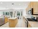 Well-lit kitchen featuring light wood cabinets, an island, and a breakfast nook with a view at 10211 Quails Landing Ave, Tampa, FL 33647