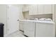 Functional laundry room features ample cabinetry, a sink, and modern appliances for efficient chores at 10211 Quails Landing Ave, Tampa, FL 33647