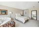 Relaxing Main bedroom features plush carpets, a sitting area, a soft color palette, and a decorative mirror at 10211 Quails Landing Ave, Tampa, FL 33647
