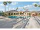 Large community pool with poolside seating, palm trees and an elegant clubhouse at 10211 Quails Landing Ave, Tampa, FL 33647