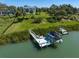 Aerial view of waterfront property with dock, boat lift, and landscaped yard at 110 Harbor View Ln, Belleair Bluffs, FL 33770