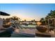 Backyard sunset view with fire pits, pool, manicured landscaping, and harbor backdrop at 110 Harbor View Ln, Belleair Bluffs, FL 33770