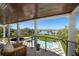 Stunning balcony view featuring a pool, lush green lawn and waterfront access with the bridge in the distance at 110 Harbor View Ln, Belleair Bluffs, FL 33770