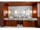 Bathroom vanity with a marble countertop and backsplash, undermount sink, wood cabinets, and storage at 110 Harbor View Ln, Belleair Bluffs, FL 33770