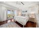 Bright bedroom with hardwood floors, white curtains, and balcony with water view at 110 Harbor View Ln, Belleair Bluffs, FL 33770