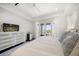Bedroom features a TV, white bedding, hardwood floors, and view of the water at 110 Harbor View Ln, Belleair Bluffs, FL 33770