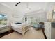 Bright bedroom with a plush bed, white furniture, and windows overlooking a scenic outdoor view at 110 Harbor View Ln, Belleair Bluffs, FL 33770