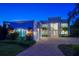 Elegant home featuring an arched entryway, grand windows, a circular driveway, and lush landscaping at 110 Harbor View Ln, Belleair Bluffs, FL 33770