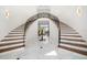 Grand foyer with a dual staircase, decorative iron railings, and elegant marble flooring at 110 Harbor View Ln, Belleair Bluffs, FL 33770