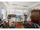 Bright home gym with hardwood floors features a treadmill, elliptical, desk, and a large window at 110 Harbor View Ln, Belleair Bluffs, FL 33770