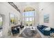 Grand living room with soaring ceilings, arched windows, balcony, and comfortable seating at 110 Harbor View Ln, Belleair Bluffs, FL 33770
