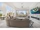 Open-concept living room with a fireplace, TV, and floor-to-ceiling windows offering a view at 110 Harbor View Ln, Belleair Bluffs, FL 33770
