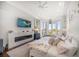 Bright main bedroom features a fireplace, hardwood floors, water view, and stylish coastal decor at 110 Harbor View Ln, Belleair Bluffs, FL 33770