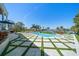 Luxury swimming pool with lush landscaping, overlooking serene waterfront views on a bright, sunny day at 110 Harbor View Ln, Belleair Bluffs, FL 33770