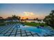 Beautiful pool with in-pool lighting and fire bowls offers tranquil sunset water views and ample lounge seating at 110 Harbor View Ln, Belleair Bluffs, FL 33770