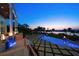 A gorgeous inground pool at twilight with fire bowls and bay views makes this outdoor space perfect for relaxing or entertaining at 110 Harbor View Ln, Belleair Bluffs, FL 33770