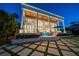 Luxury home with stately columns, a covered patio, and tiered yard with water feature and fire bowls at 110 Harbor View Ln, Belleair Bluffs, FL 33770