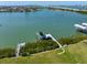 Gorgeous waterfront property featuring a private boat dock with lush greenery at 110 Harbor View Ln, Belleair Bluffs, FL 33770