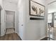 Hallway featuring a cow painting and access to the dining area and a room with a closet at 11403 Alachua Creek Ln, Riverview, FL 33579