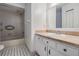 Neutral bathroom with tiled shower-tub combo, black and white tiled floor, and white vanity with tan countertop at 12025 Environmental Dr # 5, New Port Richey, FL 34654
