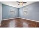 Bedroom with wood floors, ceiling fan, and two windows for natural light at 12025 Environmental Dr # 5, New Port Richey, FL 34654