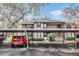 Exterior view of building with covered parking, mature trees, manicured bushes and red car parked in front at 12025 Environmental Dr # 5, New Port Richey, FL 34654